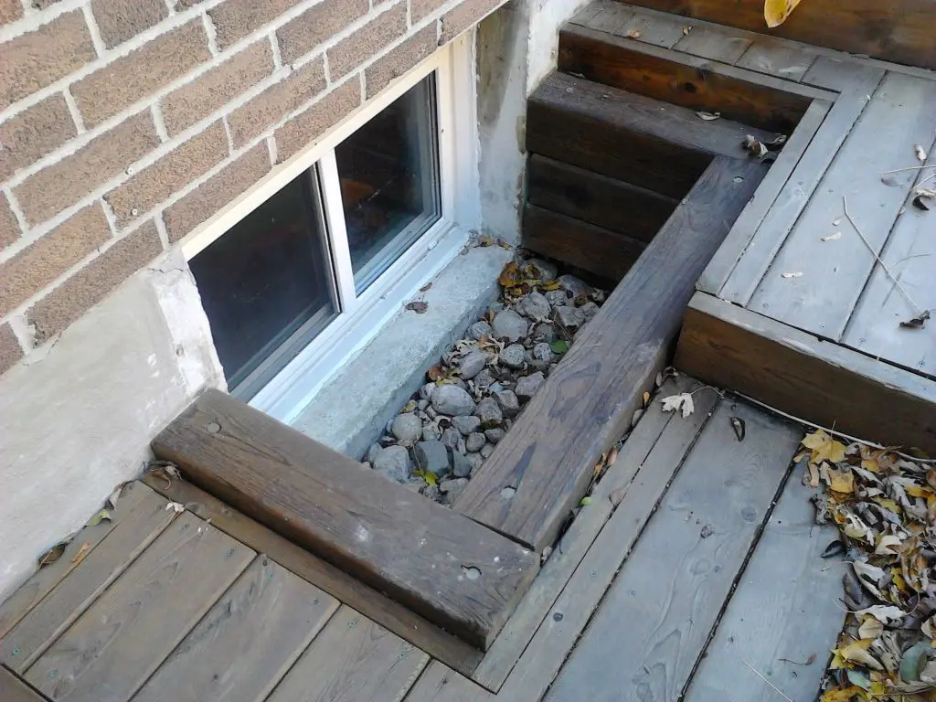 A basement window with mini stairs
