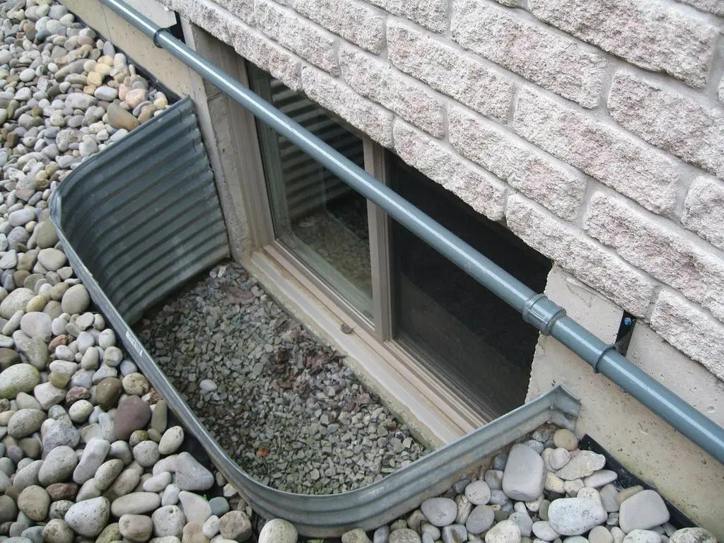 A basement window covered by a pipe